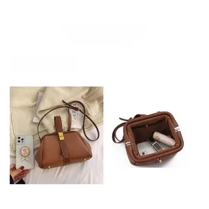 Macro detail of brown lychee grain leather handbag with spacious interior and gold clasp