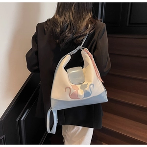 Detail of a contrast color tote bag featuring cute cat embroidery and fashion text