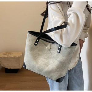 Side view of olive grey large tote bag with black leather straps on a model