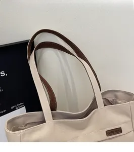Close-up of durable canvas tote bag handles with high-quality white stitching details