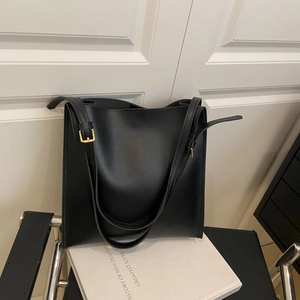 Minimalist black leather tote bag with gold buckle and large capacity for commuting
