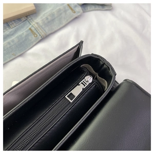 Interior detail of handbag featuring silver metal zipper and herringbone lining