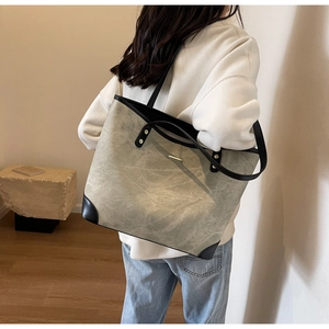 Detail view of large grey stone-patterned tote bag with black reinforced corner guards