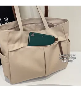 Detail of canvas tote bag showing front zipper pocket and large capacity for a tablet