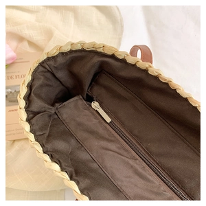 Détail du sac en paille tressée avec doublure en tissu marron et poche intérieure zippée