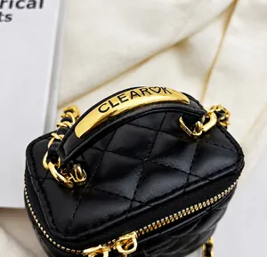 Detailed close-up of quilted black leather mini bag with gold hardware and chain strap