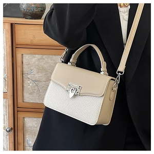 Detail of color-block crossbody bag featuring woven texture and silver metal clasp