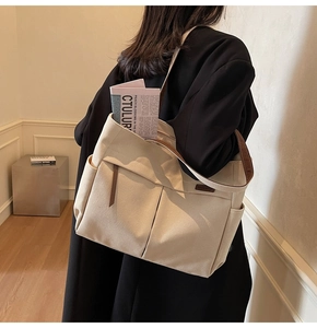 Detail of canvas tote bag showing spacious interior with leather straps and front pockets