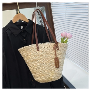 Texture détaillée d'un sac en paille tissé à la main avec sangles en cuir et rivets en métal