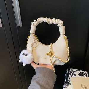 Sac demi-lune beige plissé avec bandoulière chaîne dorée et porte-clés peluche