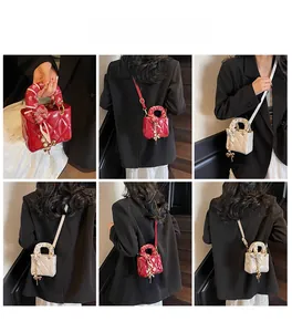 Mini quilted crossbody bag with decorative silk scarf handle and pearl bow pendant