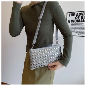 Detail of grey PU leather handbag with silver stud rivets and adjustable shoulder strap