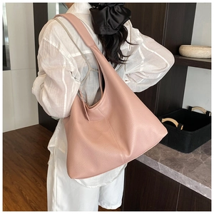 Pink lychee texture tote bag worn on shoulder showing large capacity and hobo style