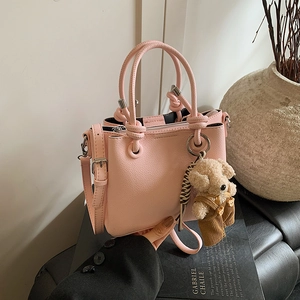 Pink lychee grain leather bucket bag with top handles and cute teddy bear charm pendant