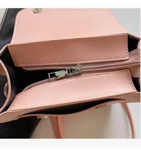 Detail shot of smooth metal zipper and high-quality leather on pink crossbody bag