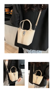 Detail of beige woven texture bucket bag with silver buckle and adjustable shoulder strap