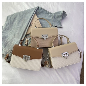 Detailed view of color-block handbags with unique metallic cone-shaped buckles and textures