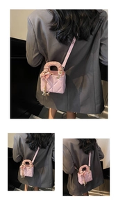 Detail of pink quilted mini crossbody bag with silk scarf handle and pearl charm pendant