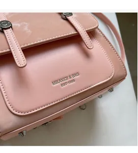 Detail view of pink PU leather handbag featuring metallic studs and decorative straps