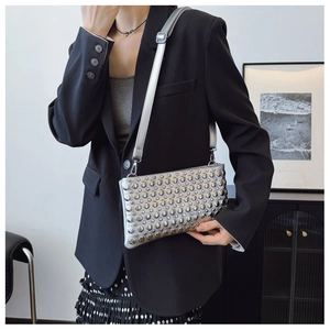 Detailed view of silver crossbody bag with uniform metallic studs and sleek shoulder strap
