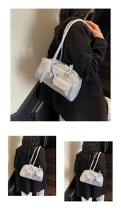 Close-up of blue Boston bag with lace bow, heart pendant, and practical front pockets