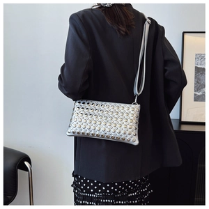 Silver crossbody bag with dense metal rivet studs and adjustable wide shoulder strap