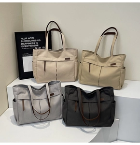 Detailed view of canvas tote bags in four colors with leather handles and side pockets