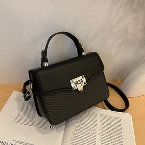 Fashionable black contrast panel handbag with silver metal twist lock and top handle