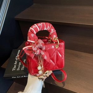 Quilted mini handbag in red leather with decorative silk scarf and golden charms