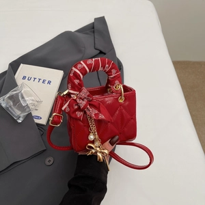 Chic red quilted mini handbag with printed silk scarf handle and pearl charm detail