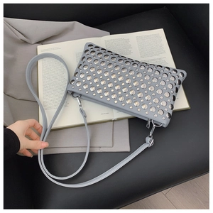 Detail of light blue PU leather handbag with silver metallic studs and detachable strap