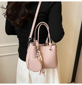 Pink lychee texture bucket bag with dual ring handles and round coin purse charm detail