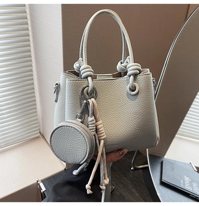 Detail of light blue lychee pattern bucket bag with knot handle and round coin purse charm