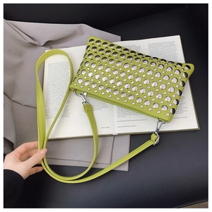 Detail of avocado green PU leather handbag featuring silver metal rivets and strap