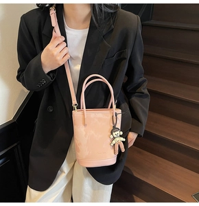 Détail du sac seau rose avec texture ondulée et pendentif singe mignon