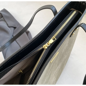 Detailed macro shot of the golden zipper and sleek grey-green tote bag interior