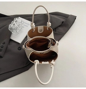 Close-up of beige bucket bag interior with magnetic closure and textured leather finish