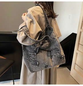 Detail of vintage gray denim tote bag with reconstructed pocket design and shoulder strap