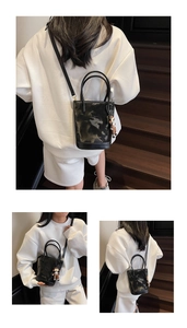 Détail du sac seau bicolore avec breloque singe et finition à motif marbré