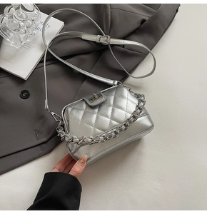 Dettaglio mini borsa a tracolla argento trapuntata con chiusura a scatto stile vintage