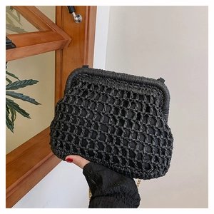 Close-up of black woven cloud bag with gold chain and vintage frame clasp detail