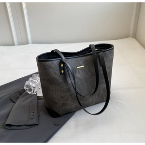 Detail view of large charcoal tote bag with vintage texture and gold hardware accents