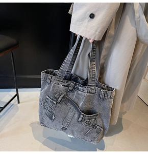 Detail view of a vintage denim tote bag with functional pockets and washed texture