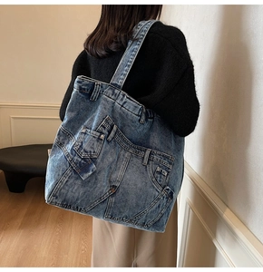 Detail view of a vintage denim tote bag showing patchwork pockets and metal rivet details