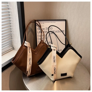Detailed view of pleated tote bags with vertical textures and chic decorative ribbons