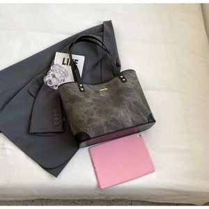 Grey tote bag detail with golden metal bar and marble textured material for business