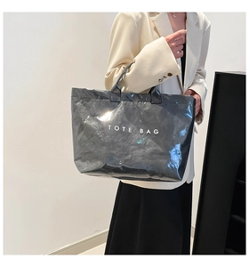 Detail view of the black Tyvek and PVC tote bag with stylish white TOTE BAG printing