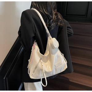 Détail du sac cabas blanc crème avec cuir plissé et décoration de ruban latéral
