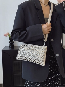 Chic cream leather handbag with silver stud rivets worn with a black blazer outfit