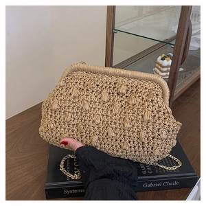 Detail of woven straw handbag with popcorn texture and golden metal clasp closure